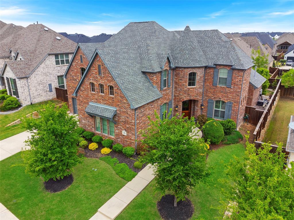 a aerial view of a brick house next to a yard