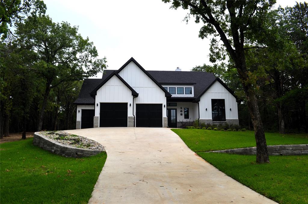 a front view of a house with a yard and trees