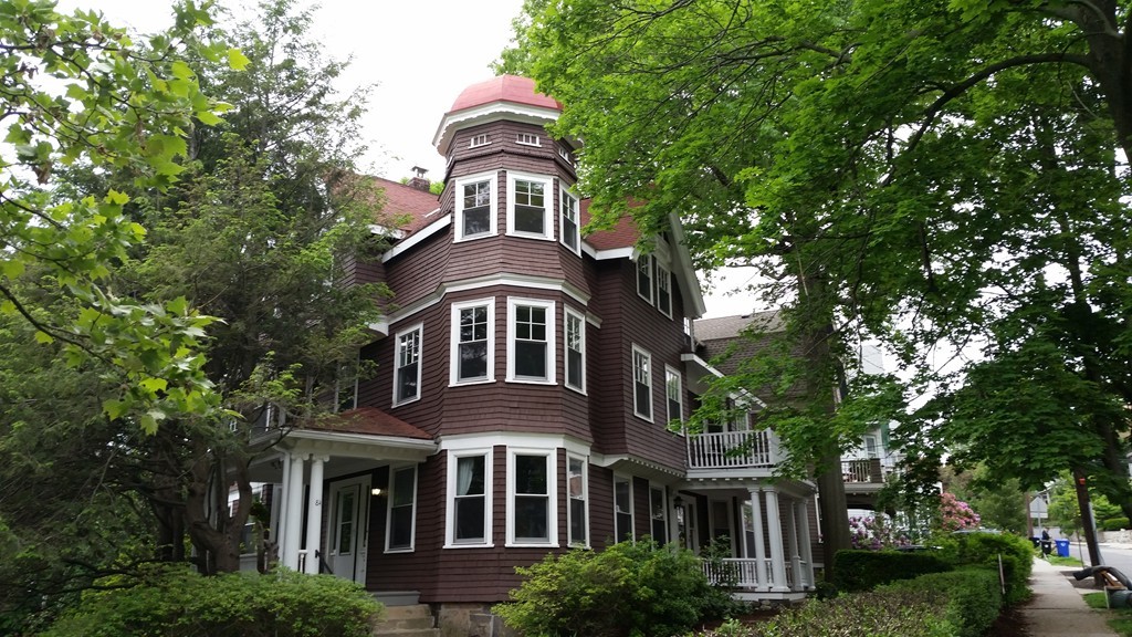 a front view of a house with yard and trees