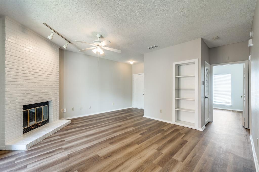 a view of empty room with wooden floor and fireplace