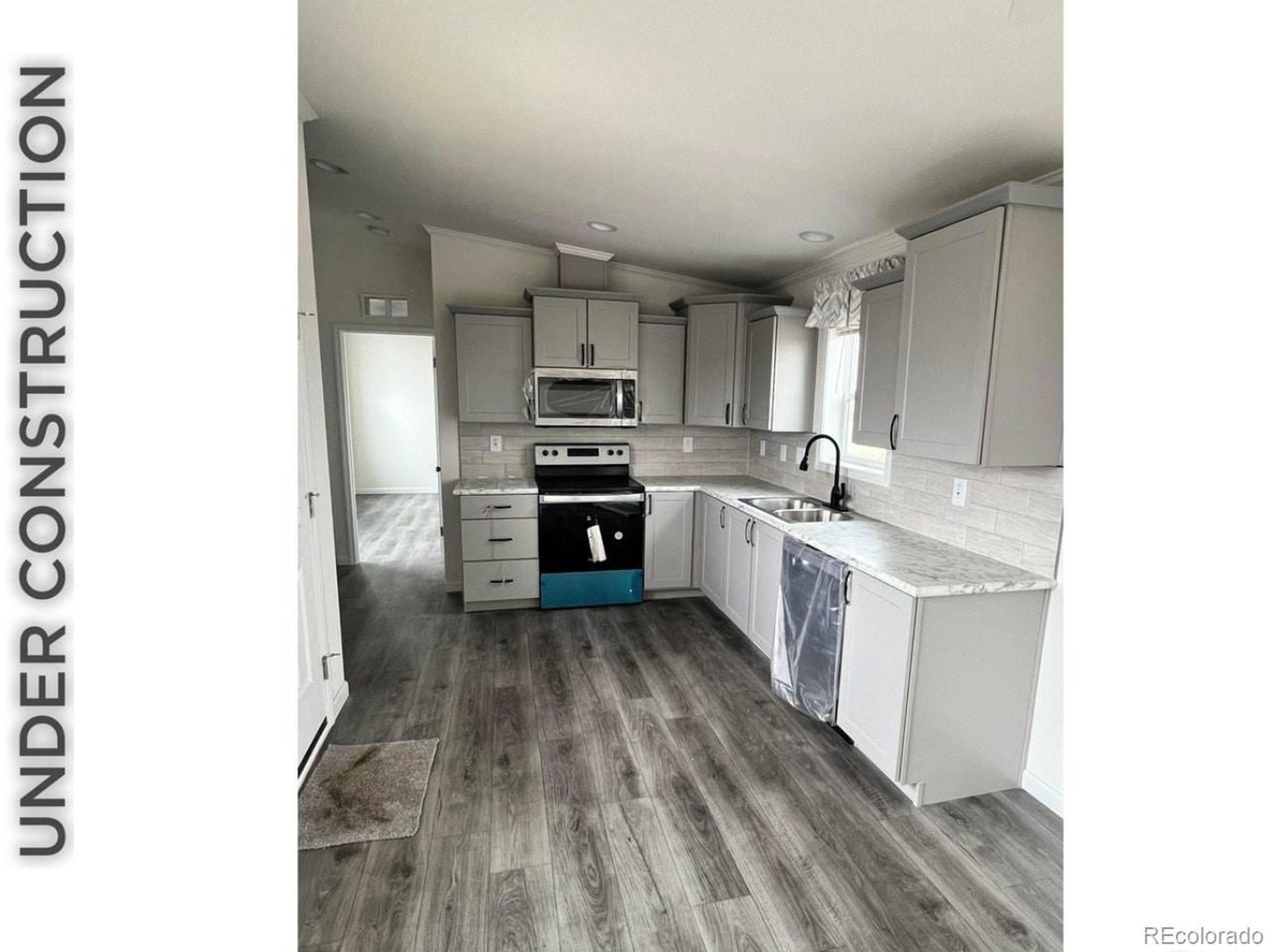 a large kitchen with cabinets wooden floor and stainless steel appliances