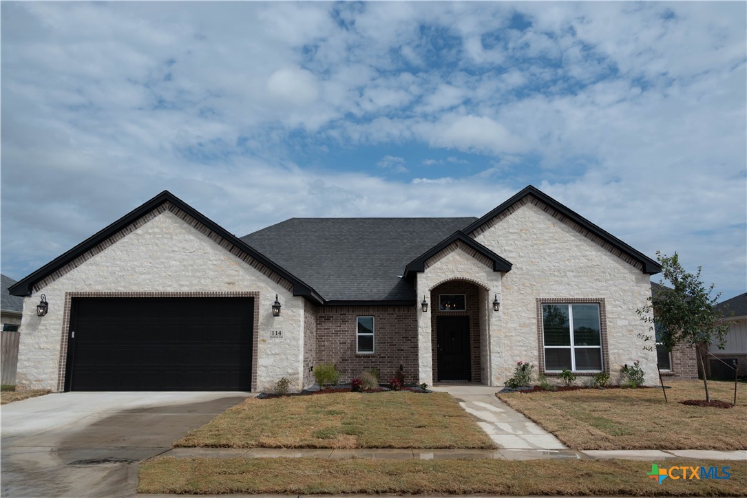 a front view of a house with a yard and garage