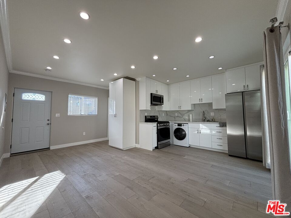 a kitchen with stainless steel appliances kitchen island granite countertop a refrigerator and a sink