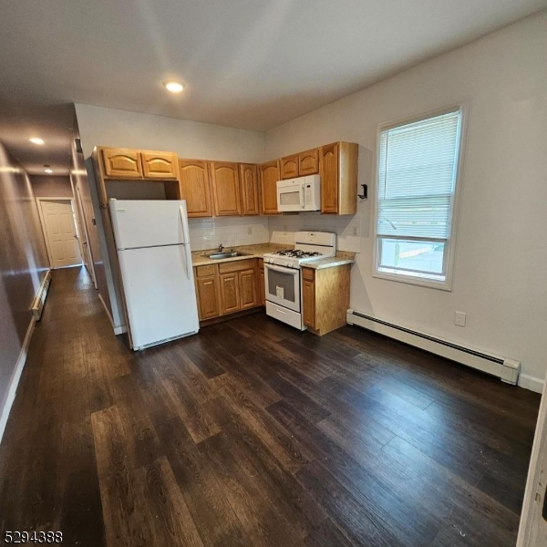 a kitchen with stove and wooden floor