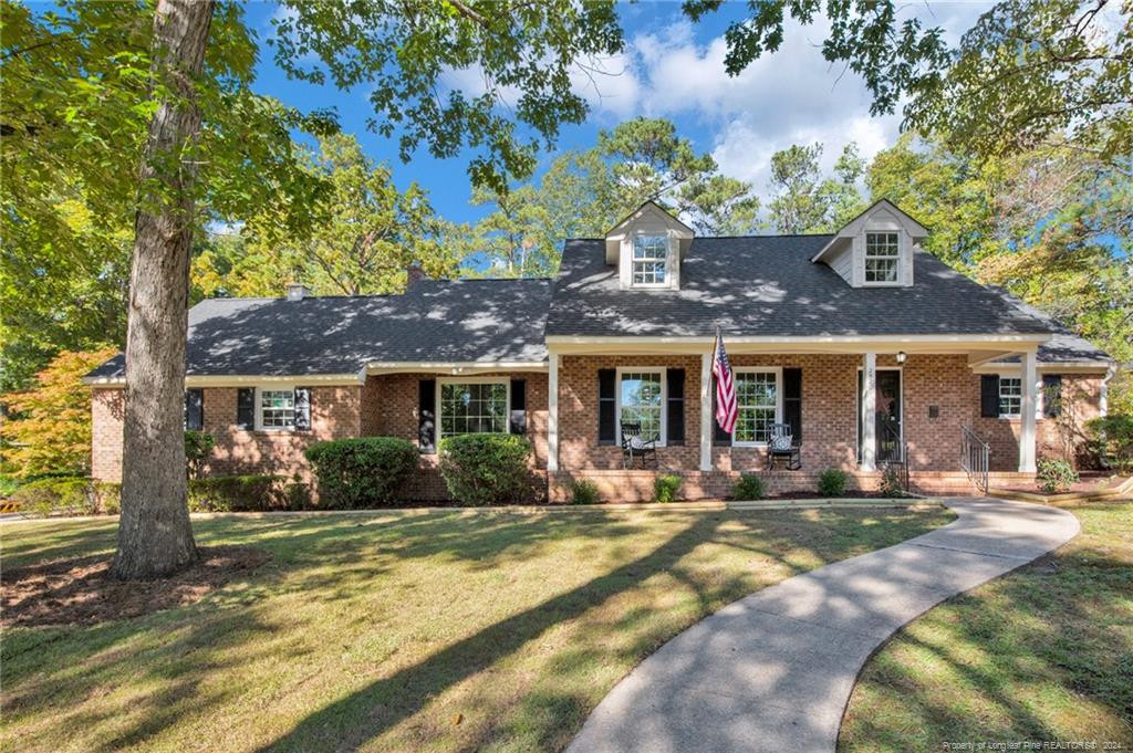 a front view of a house with a yard and outdoor seating