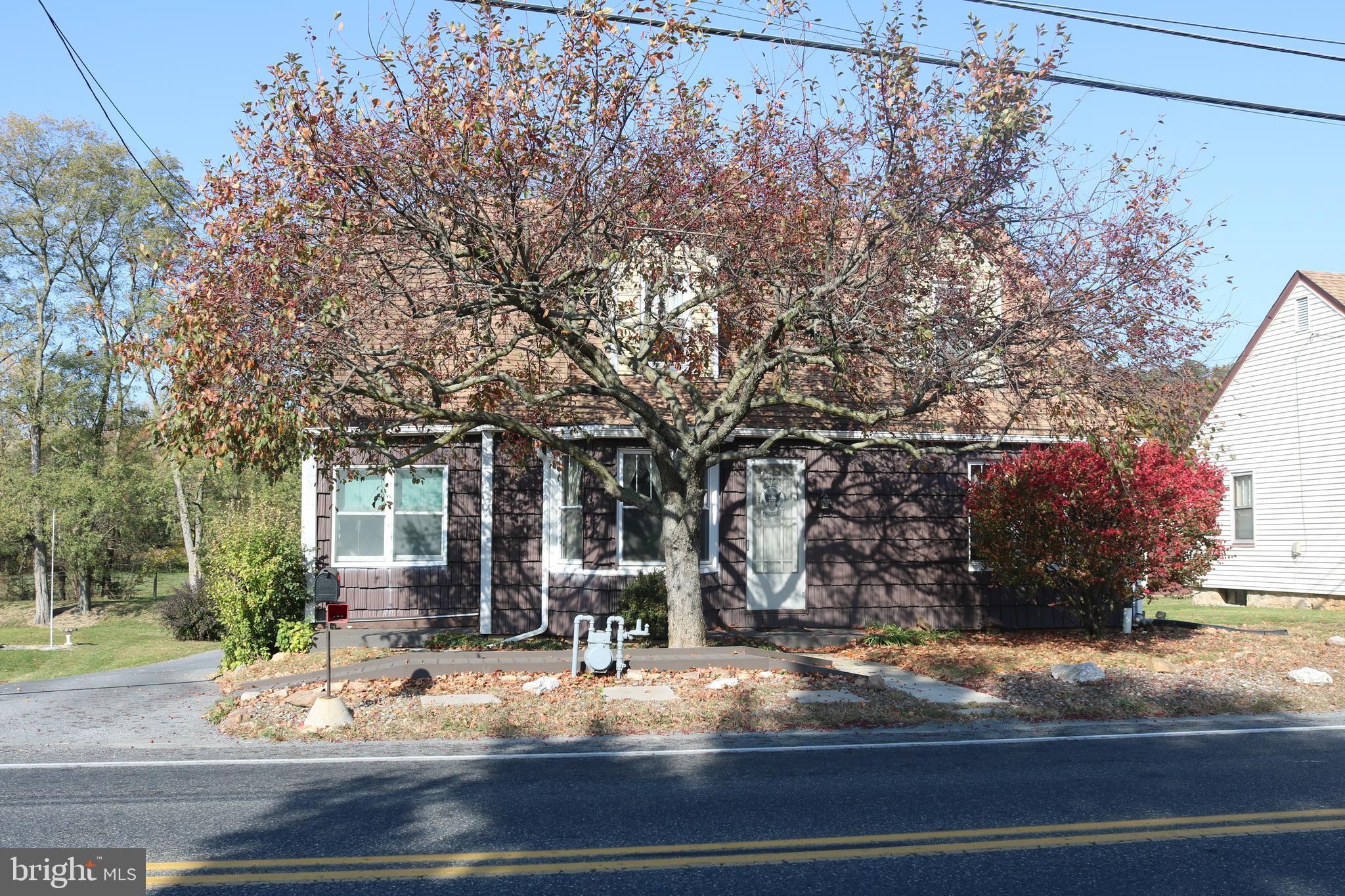 a view of a house with a yard and tree s