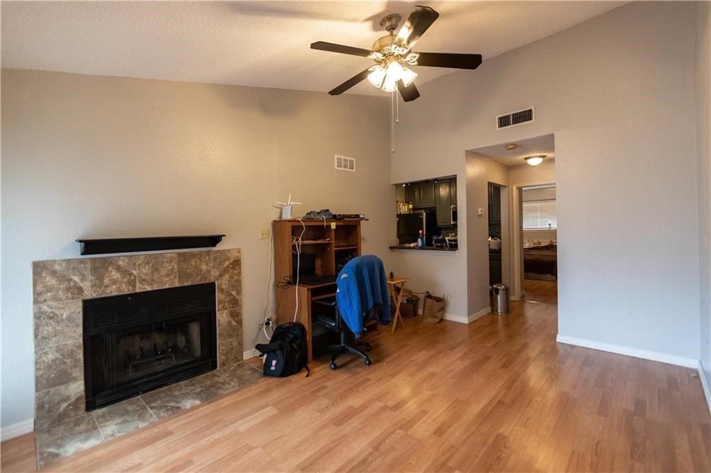 a view of a livingroom with a fireplace and a ceiling fan