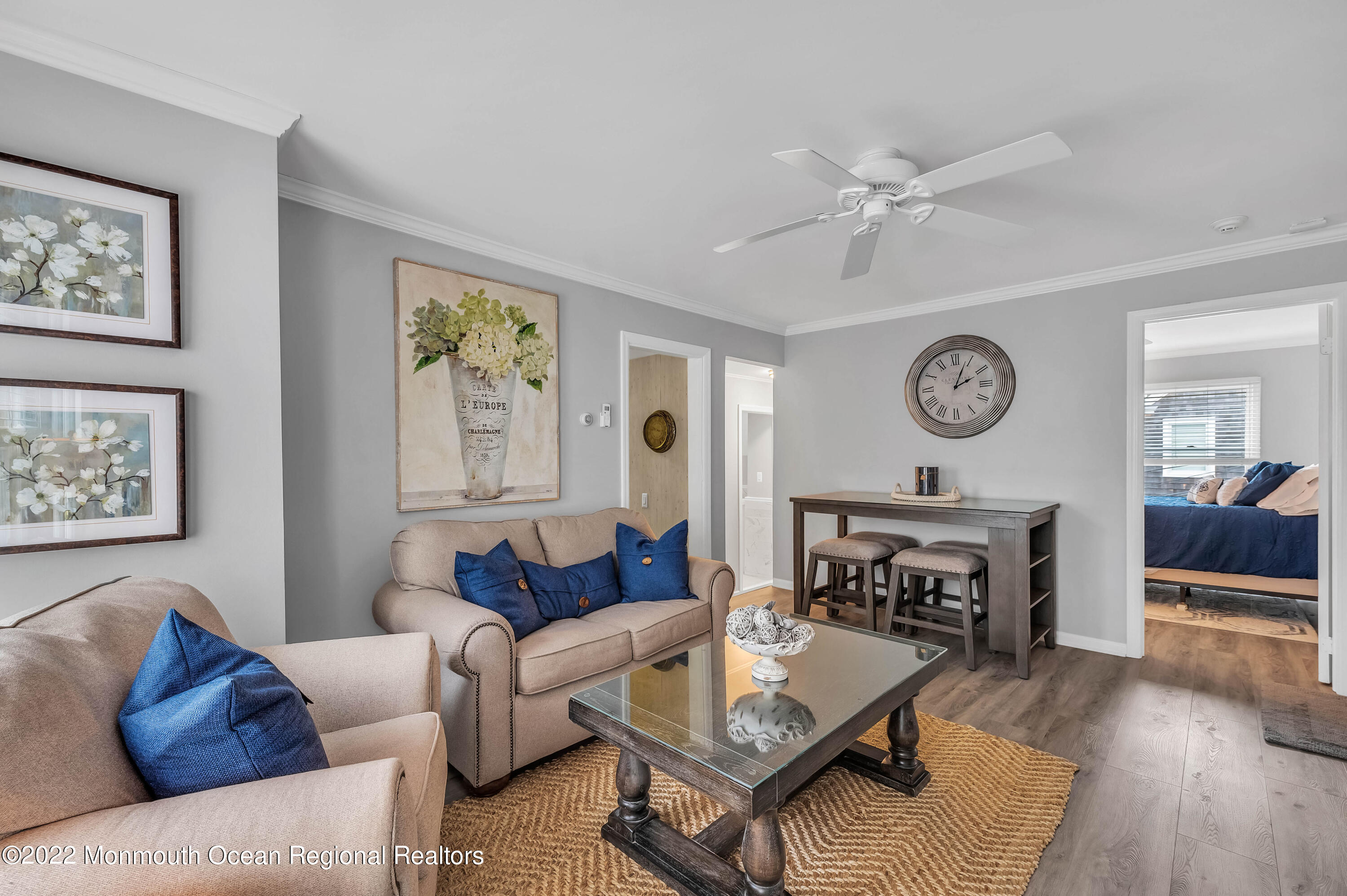 a living room with furniture a clock on wall and a fireplace