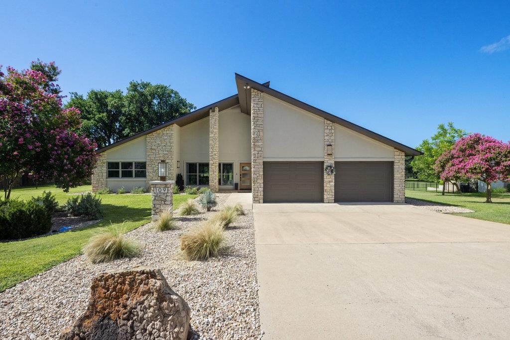 a front view of a house with garden and patio