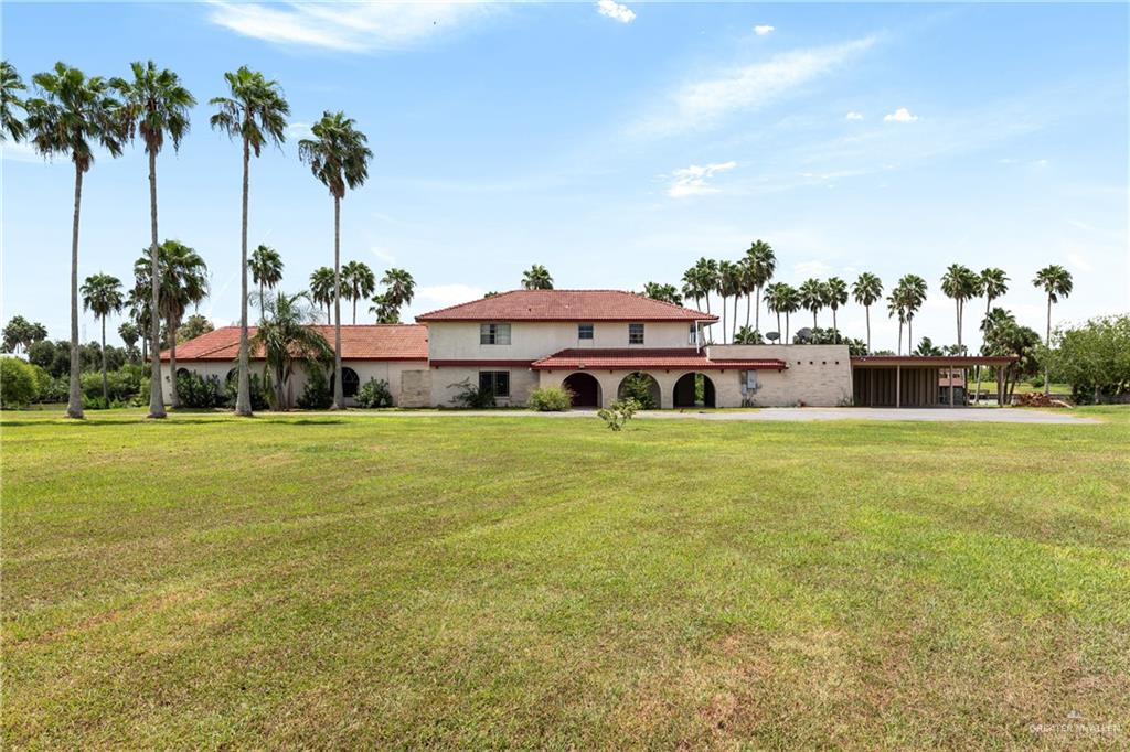 a front view of a house with a garden and trees