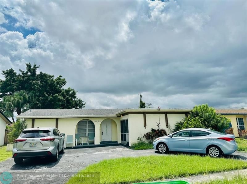 a front view of a house with cars parked