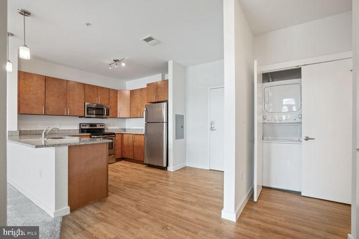 a kitchen with stainless steel appliances granite countertop a refrigerator and a stove top oven