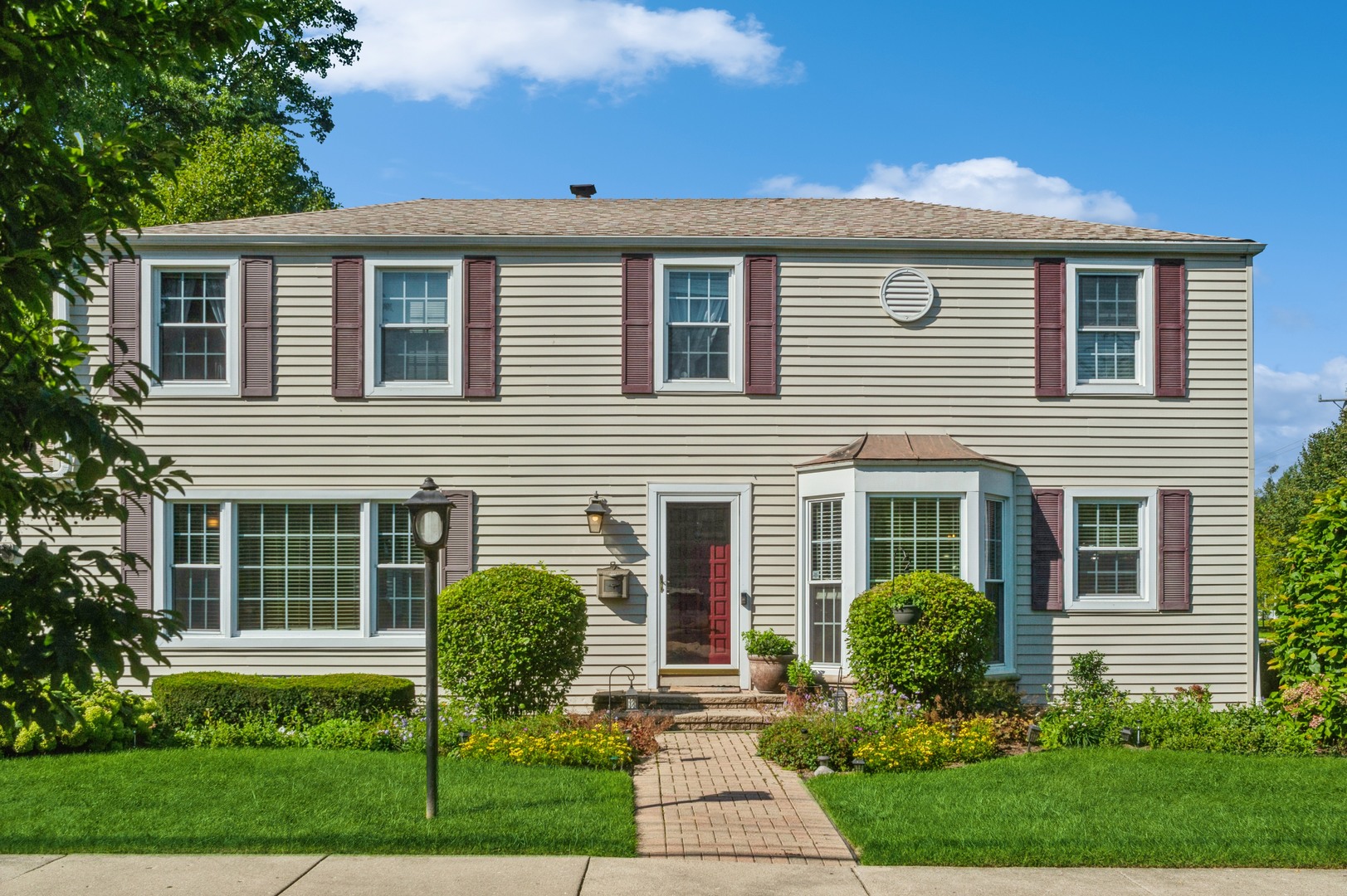 a front view of house with yard and green space