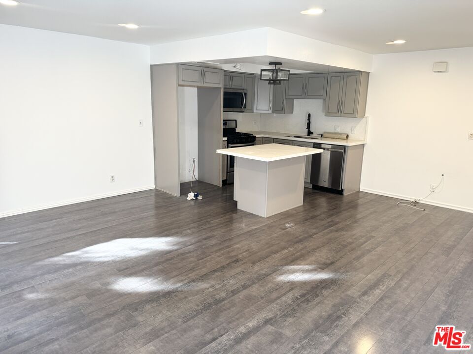 a large kitchen with kitchen island a sink stainless steel appliances and cabinets