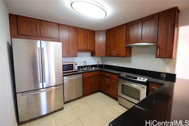 a kitchen with stainless steel appliances granite countertop a refrigerator a sink dishwasher a stove and a refrigerator