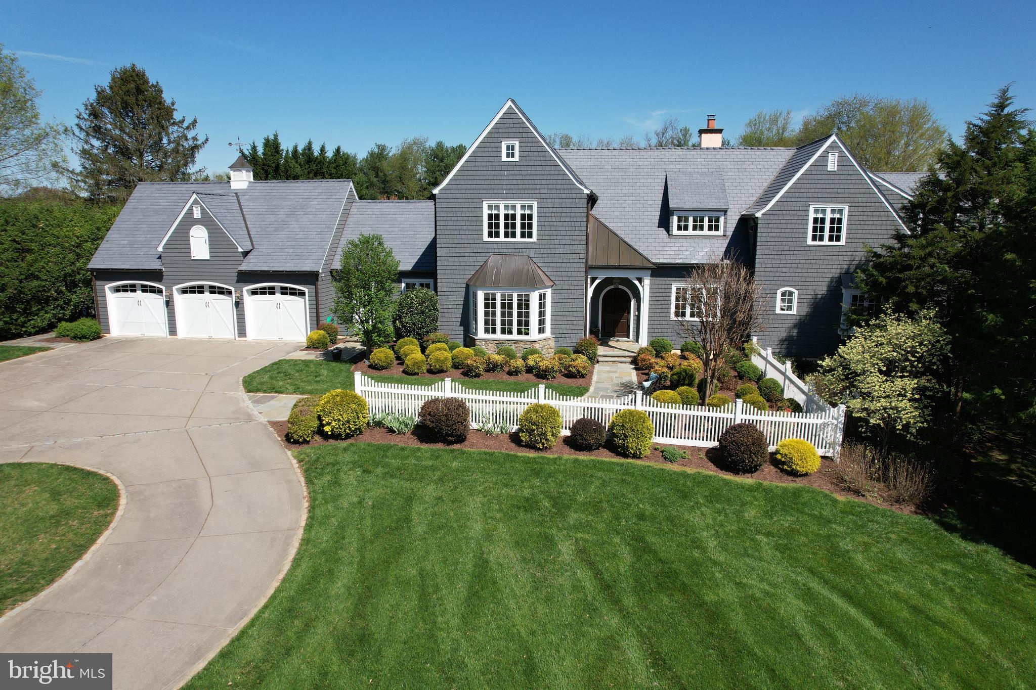 a front view of a house with garden and trees