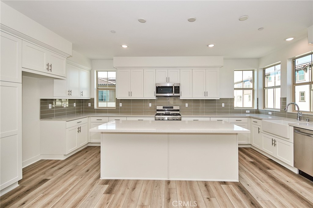 a kitchen with stainless steel appliances granite countertop white cabinets a sink and a oven