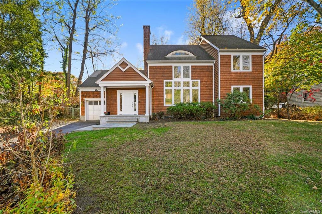 View of front facade featuring a front lawn and a garage