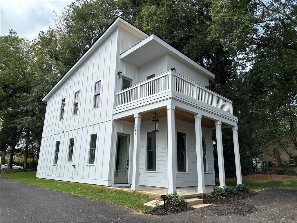 a view of a white house with large windows and a small yard