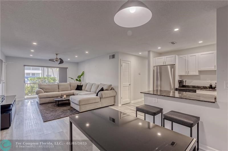 a living room with furniture and kitchen view