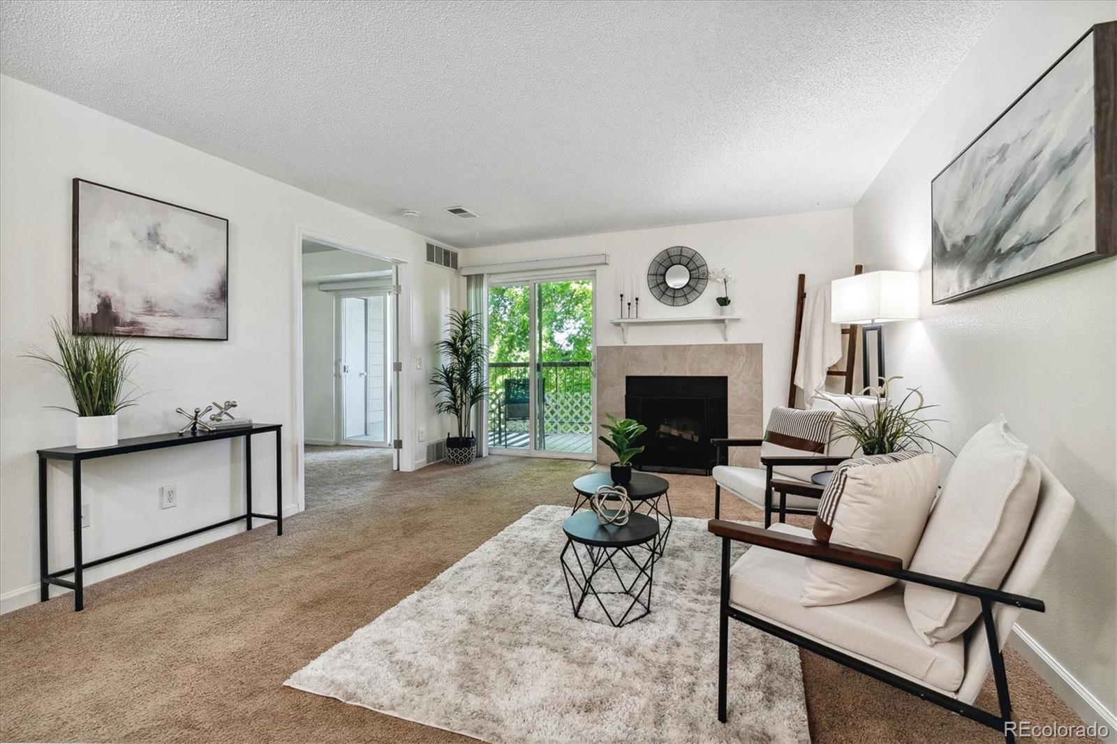 a living room with furniture a fireplace and a large window