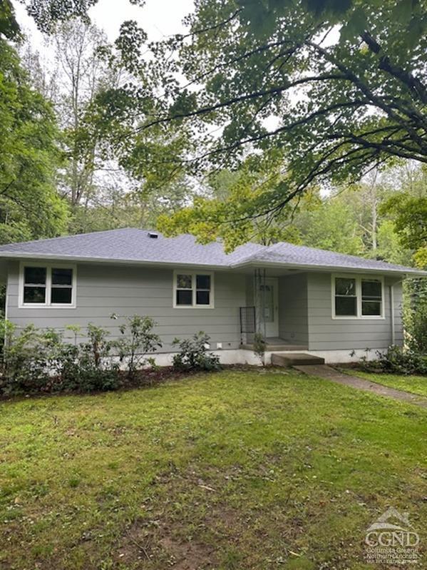 a front view of house with yard and outdoor seating