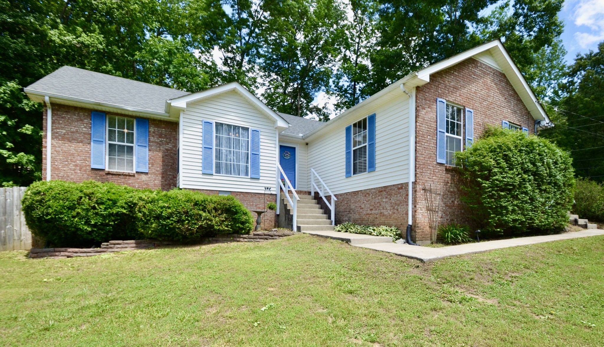 a front view of a house with a yard and potted plants