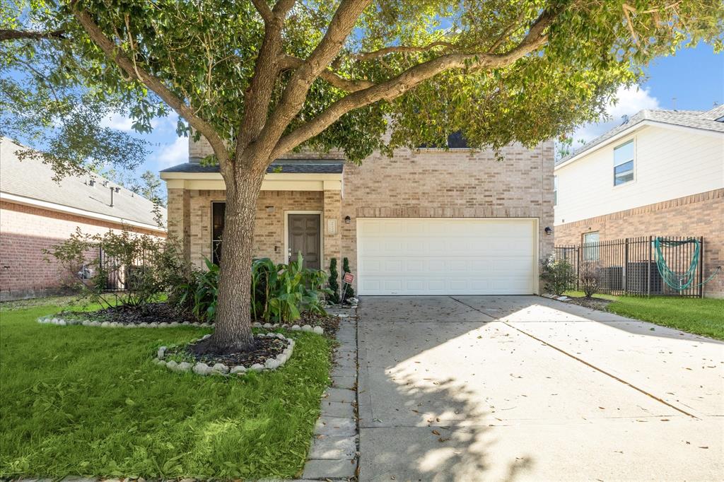 a front view of a house with a yard and an trees