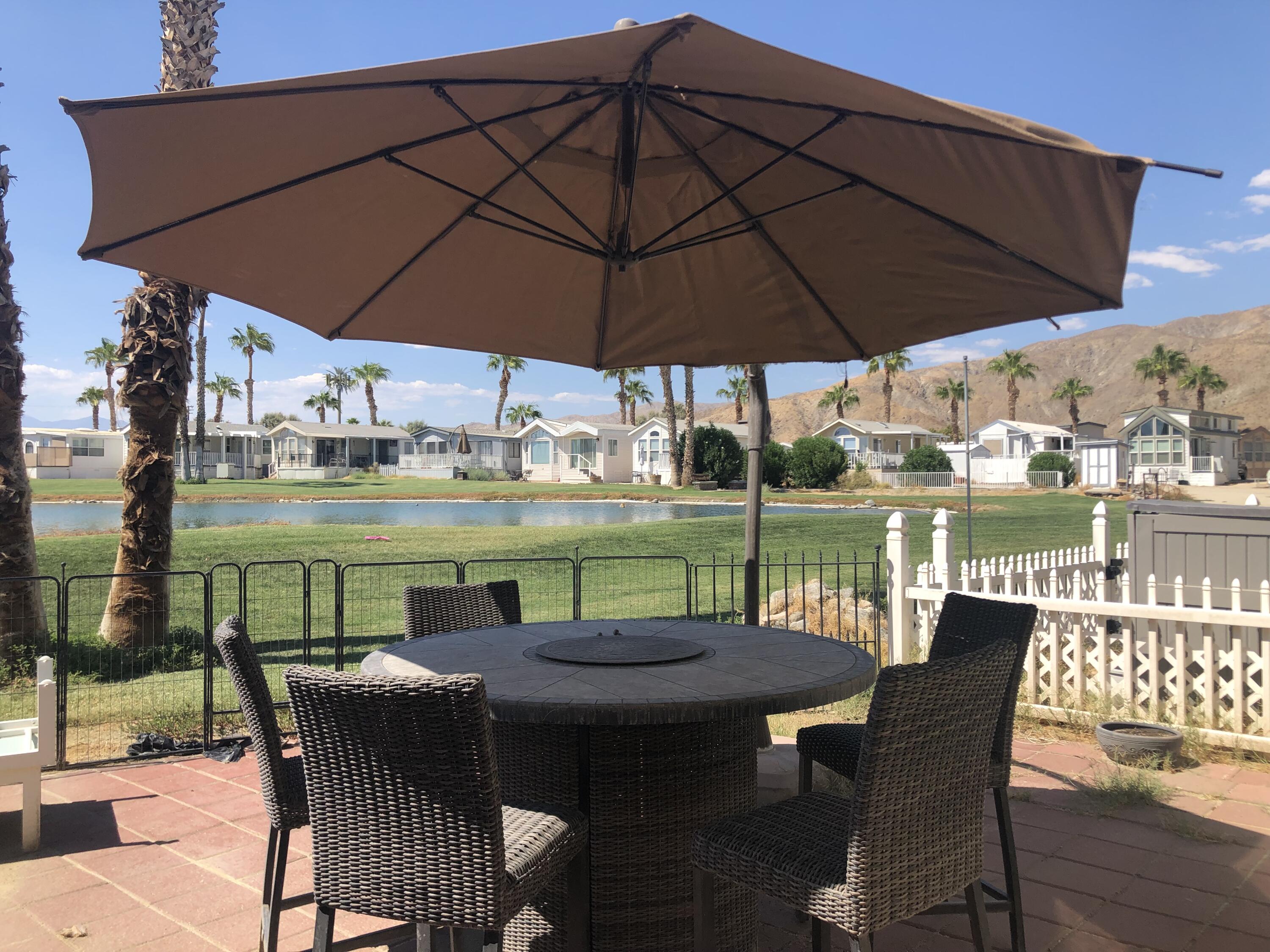 a view of a patio with table and chairs under an umbrella