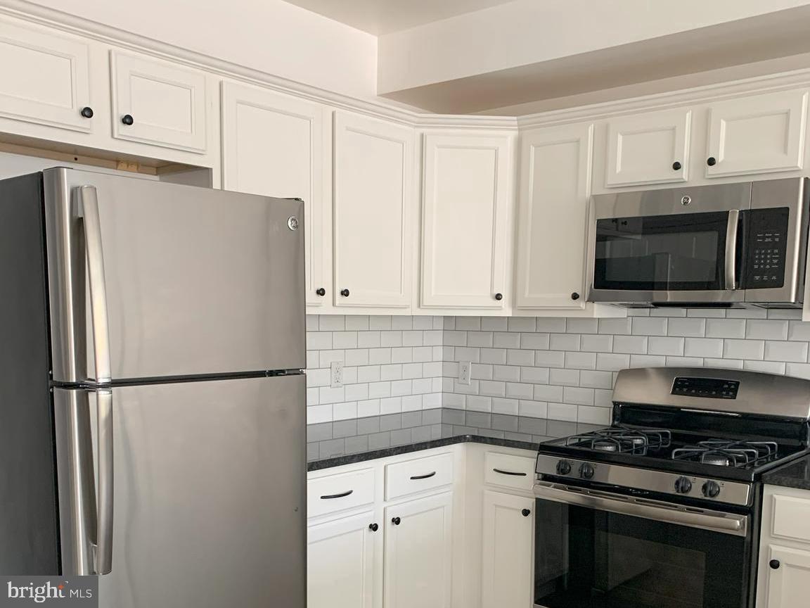 a kitchen with stainless steel appliances a refrigerator stove and microwave