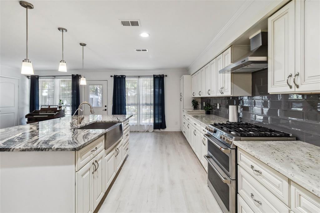 a large kitchen with stainless steel appliances granite countertop a stove and a sink