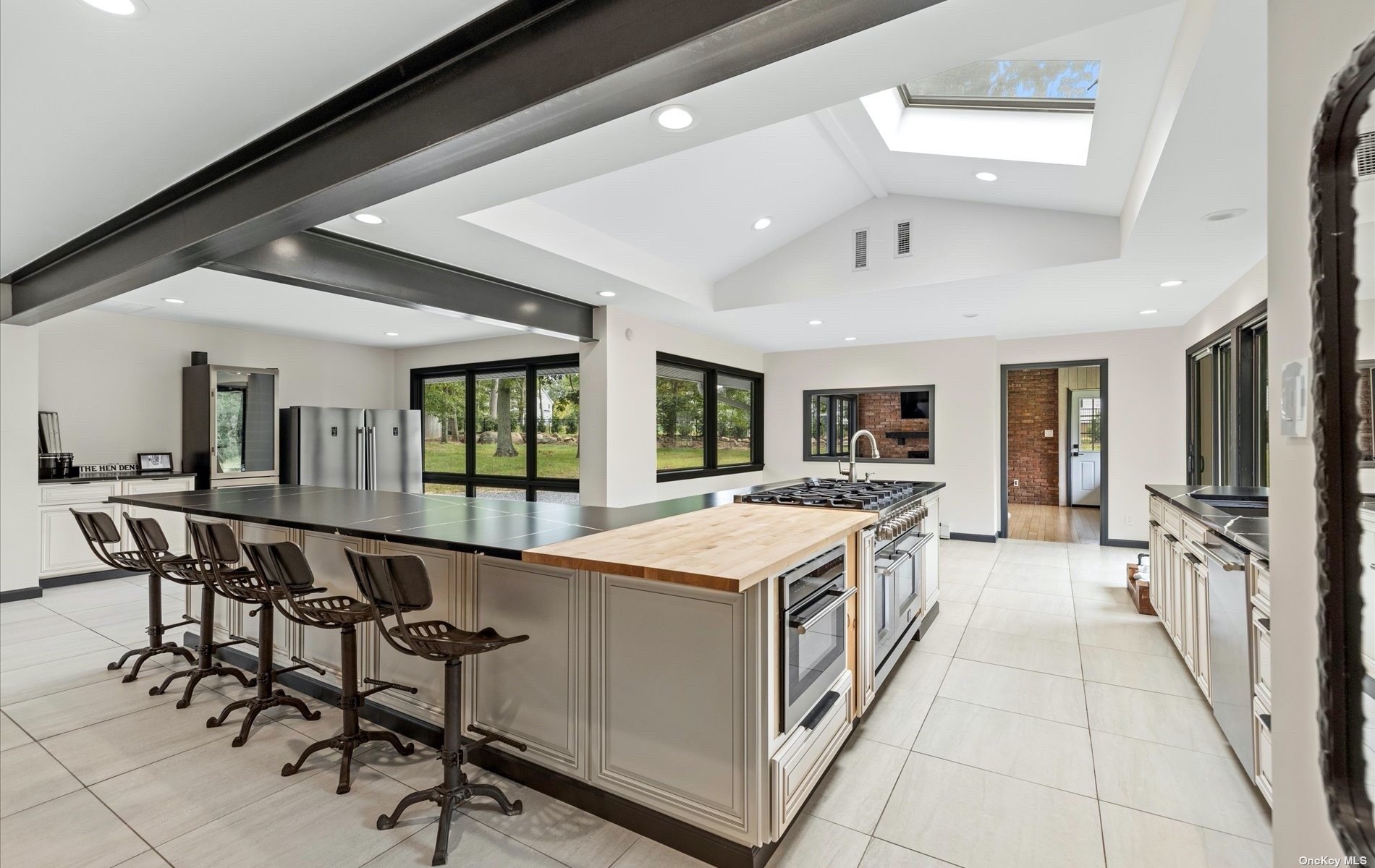 a large white kitchen with a stove and a large window