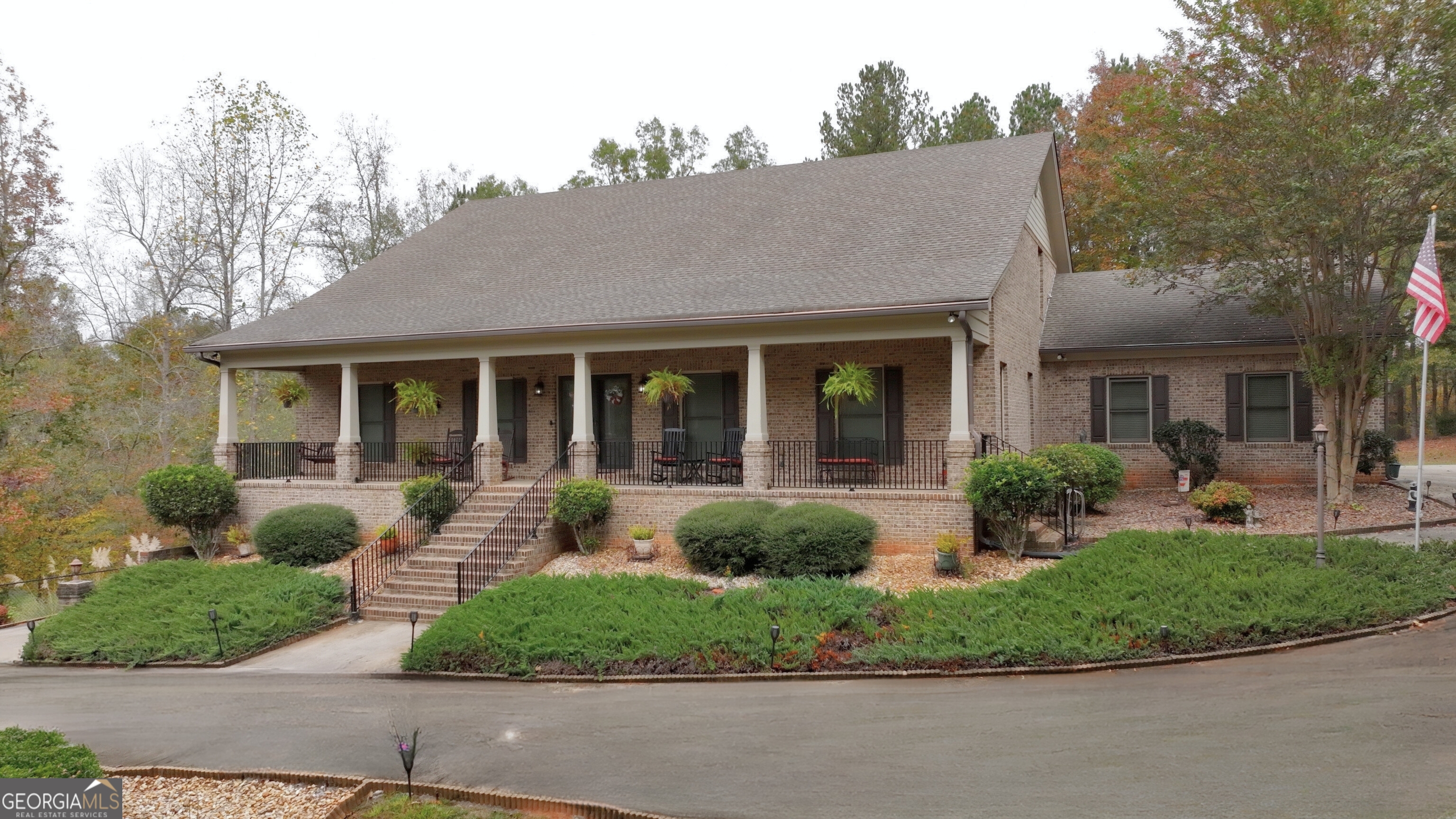 a front view of a house with porch and garden