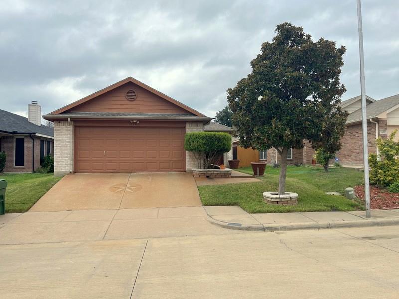 a front view of a house with a yard and trees