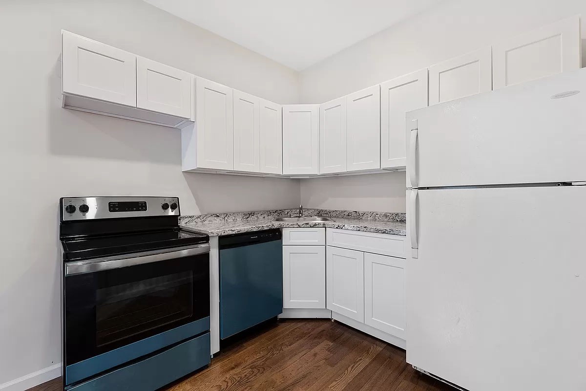 a kitchen with granite countertop white cabinets and white appliances