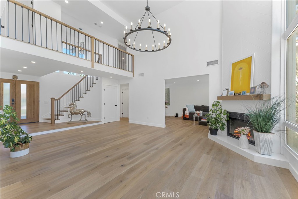 a view of a livingroom with a fireplace a chandelier and wooden floor