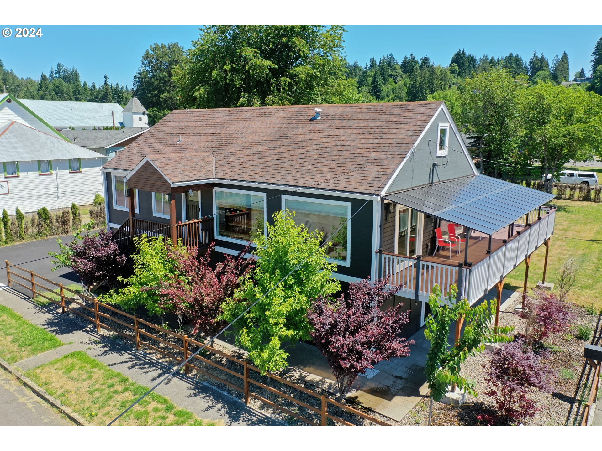 a aerial view of a house with a yard plants and large tree