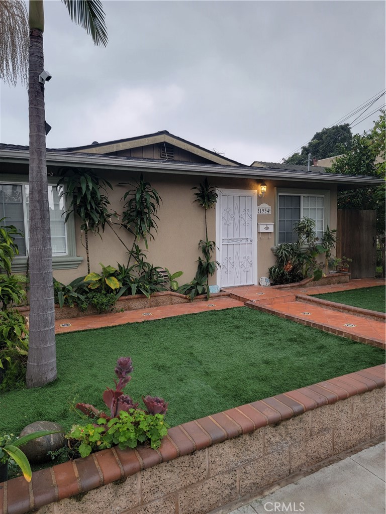 a front view of a house with a garden and plants