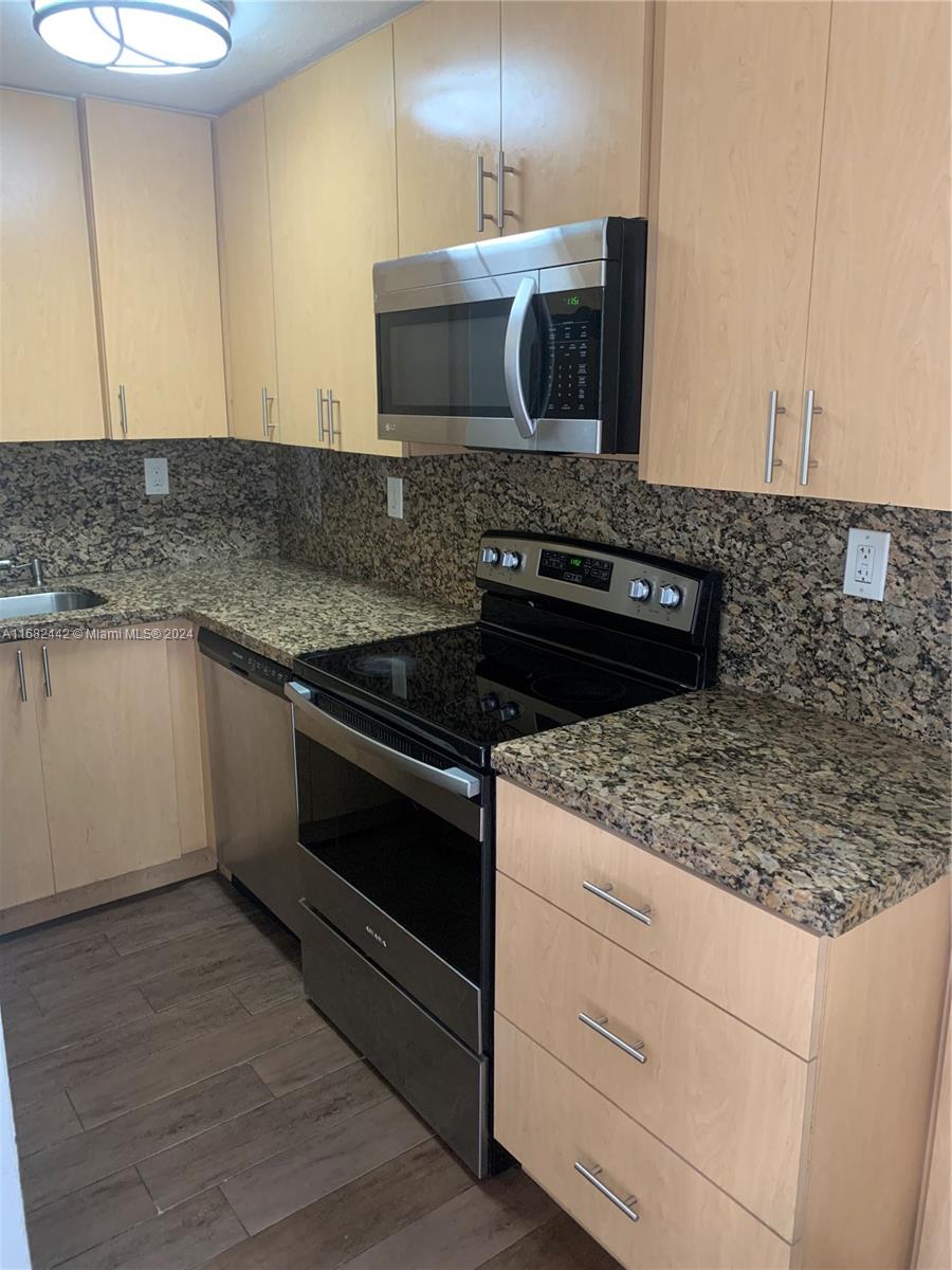 a kitchen with granite countertop a stove and a sink