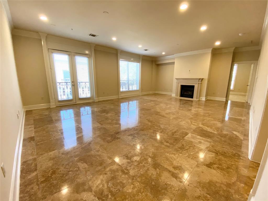 a view of an empty room with glass door and windows