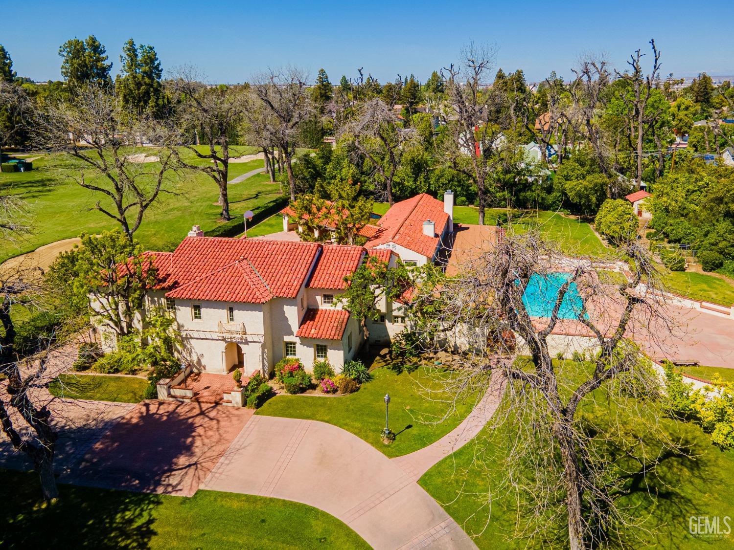 an aerial view of a house with a swimming pool a patio and mountain view