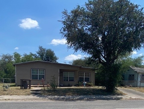 a front view of house with yard and trees in the background