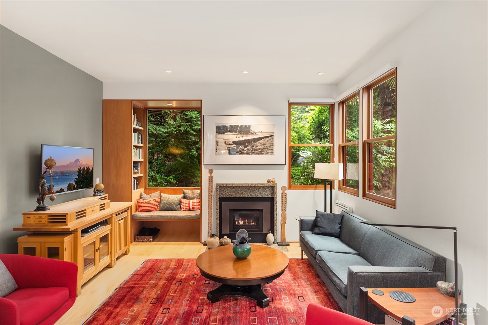 a living room with furniture a fireplace and a floor to ceiling window