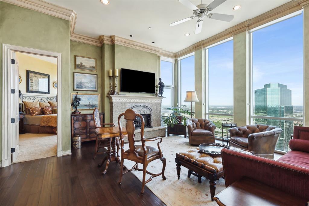 a living room with furniture floor to ceiling window hardwood floor and a flat screen tv