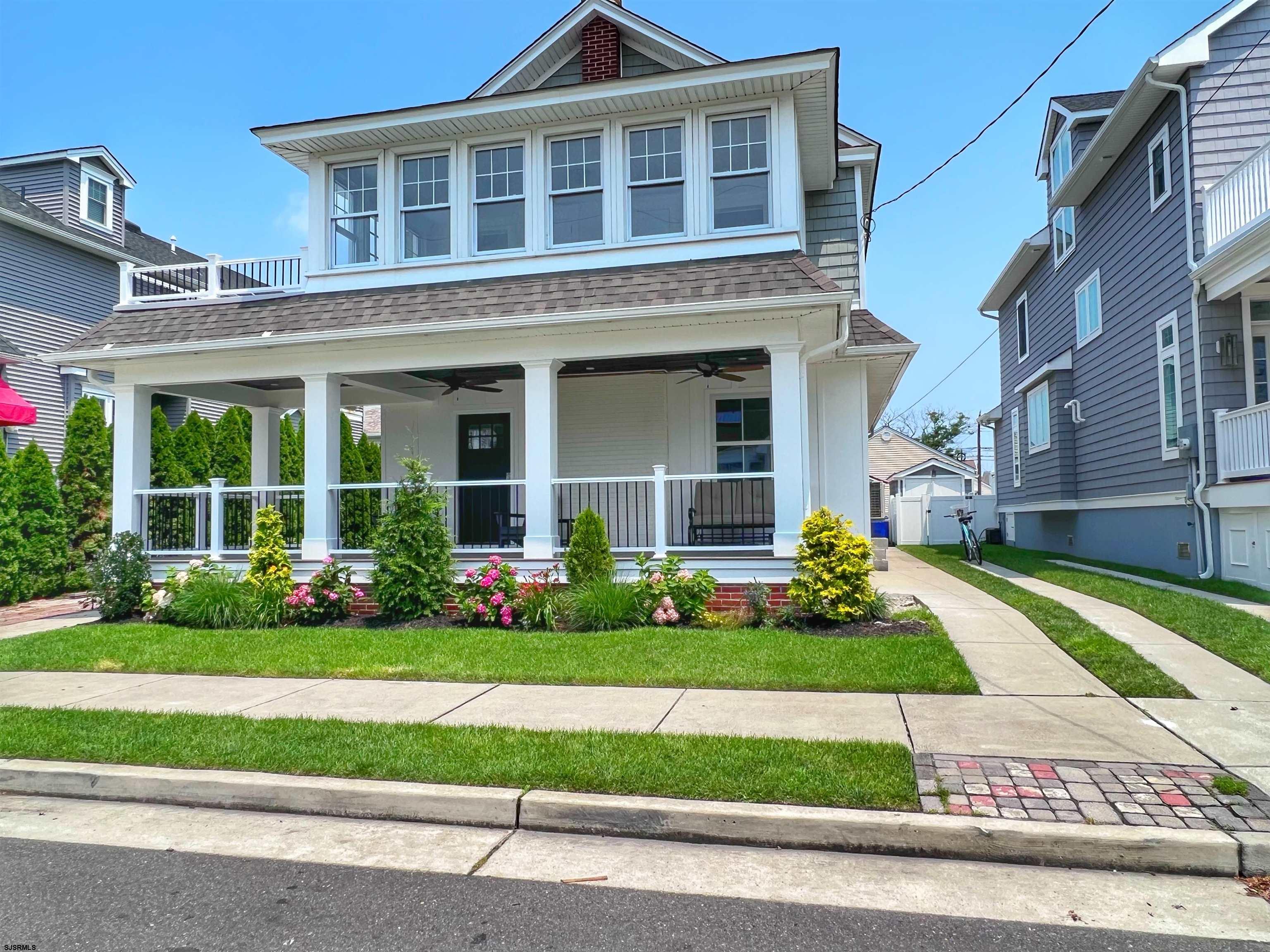 a front view of a house with a yard and potted plants