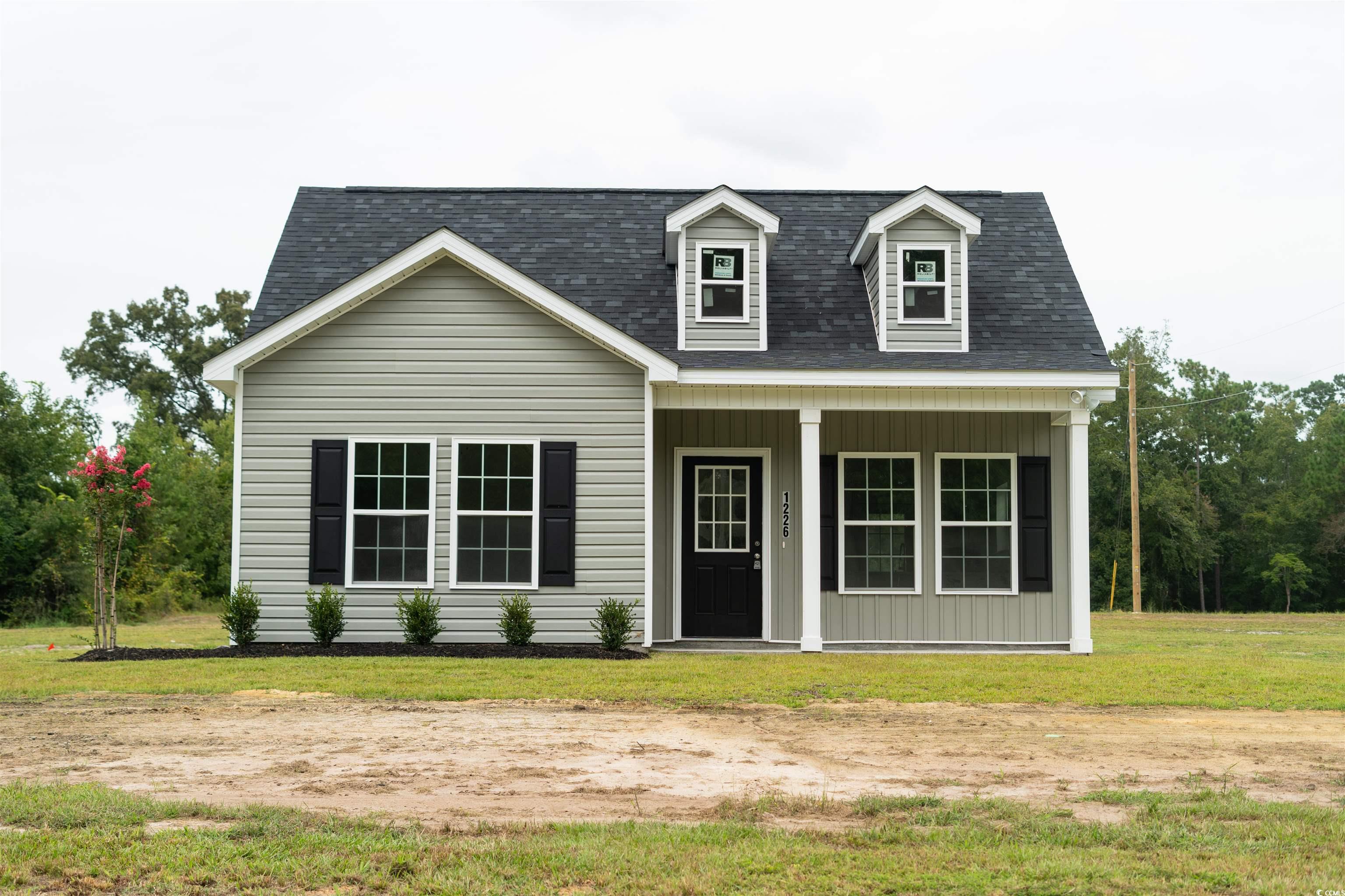 Cape cod-style house featuring a front yard and a