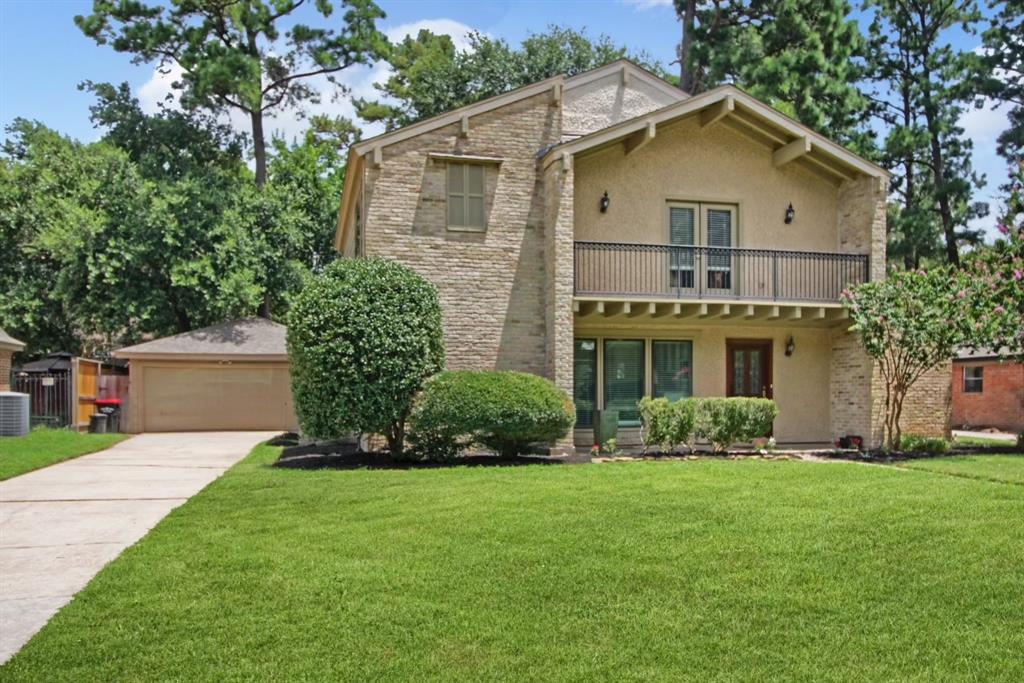 a front view of a house with a yard and trees