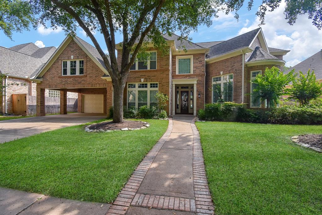 a front view of a house with yard and green space