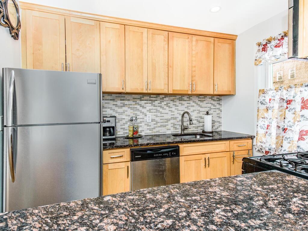 a kitchen with stainless steel appliances granite countertop a refrigerator sink and cabinets