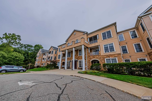 a front view of a building with cars parked